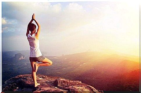 Woman on mountain top practices yoga for weight loss