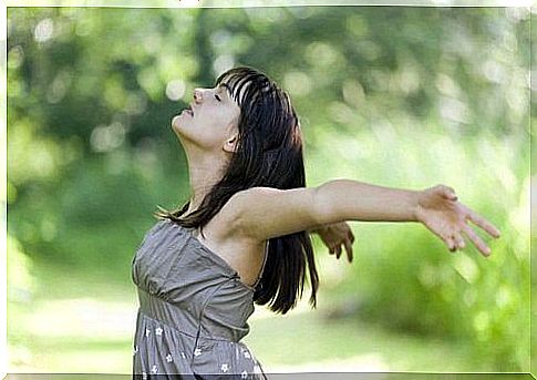 Woman standing with arms outstretched and breathing deeply