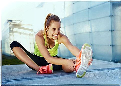 A woman stretches out on the ground.