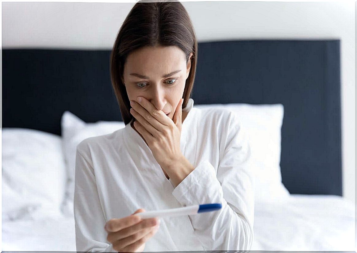 Woman looks surprised at pregnancy test