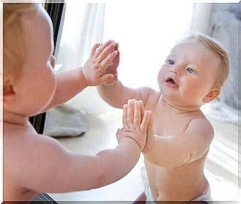 A baby in front of a mirror