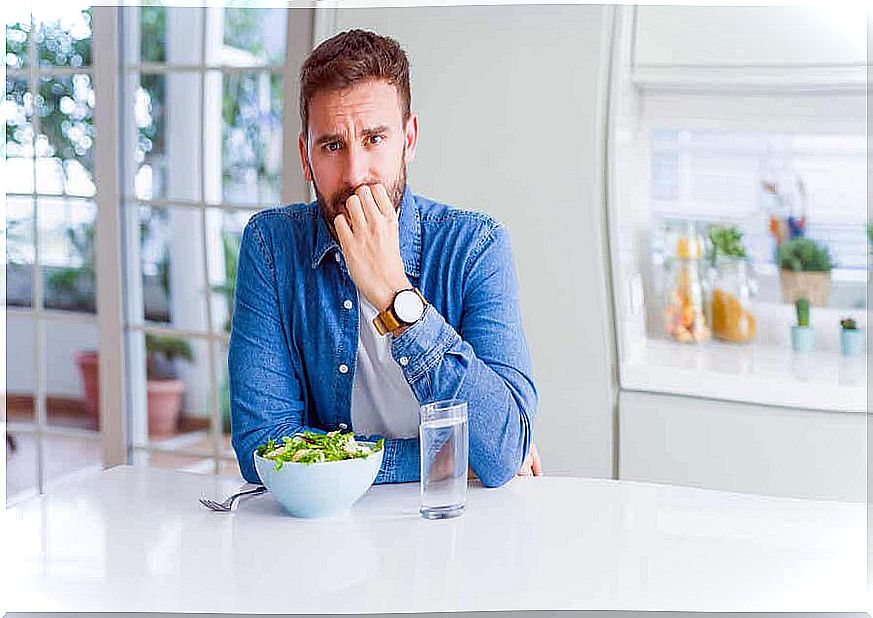 Man with salad looks anxious