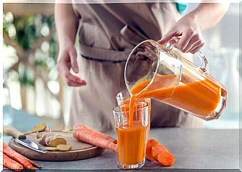 Woman making homemade carrot juice