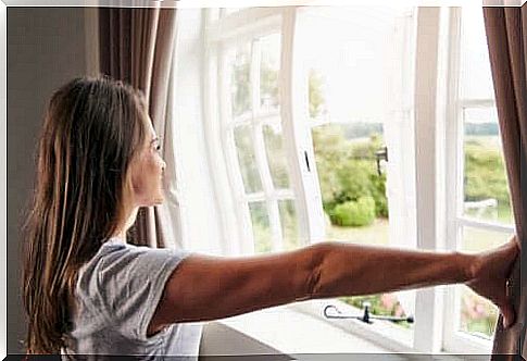 Woman ventilates to clean the air in the home