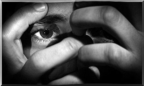 Person looking out through his fingers - repressed emotions can