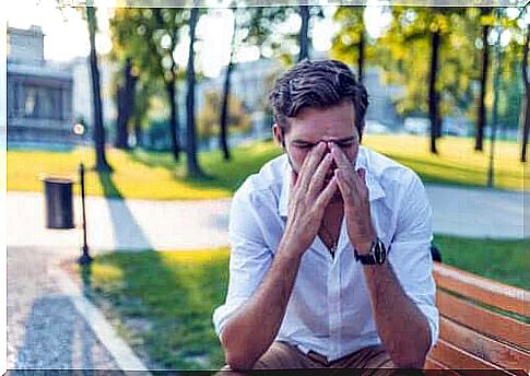 Man taking care of nose in park experiencing asthma and rhinitis