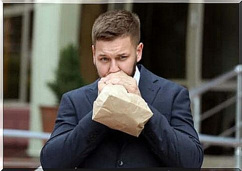 Man breathing in paper bag due to anxiety