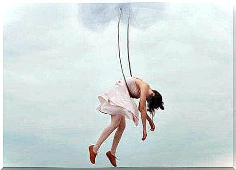 Ballerina hanging in ropes in sky